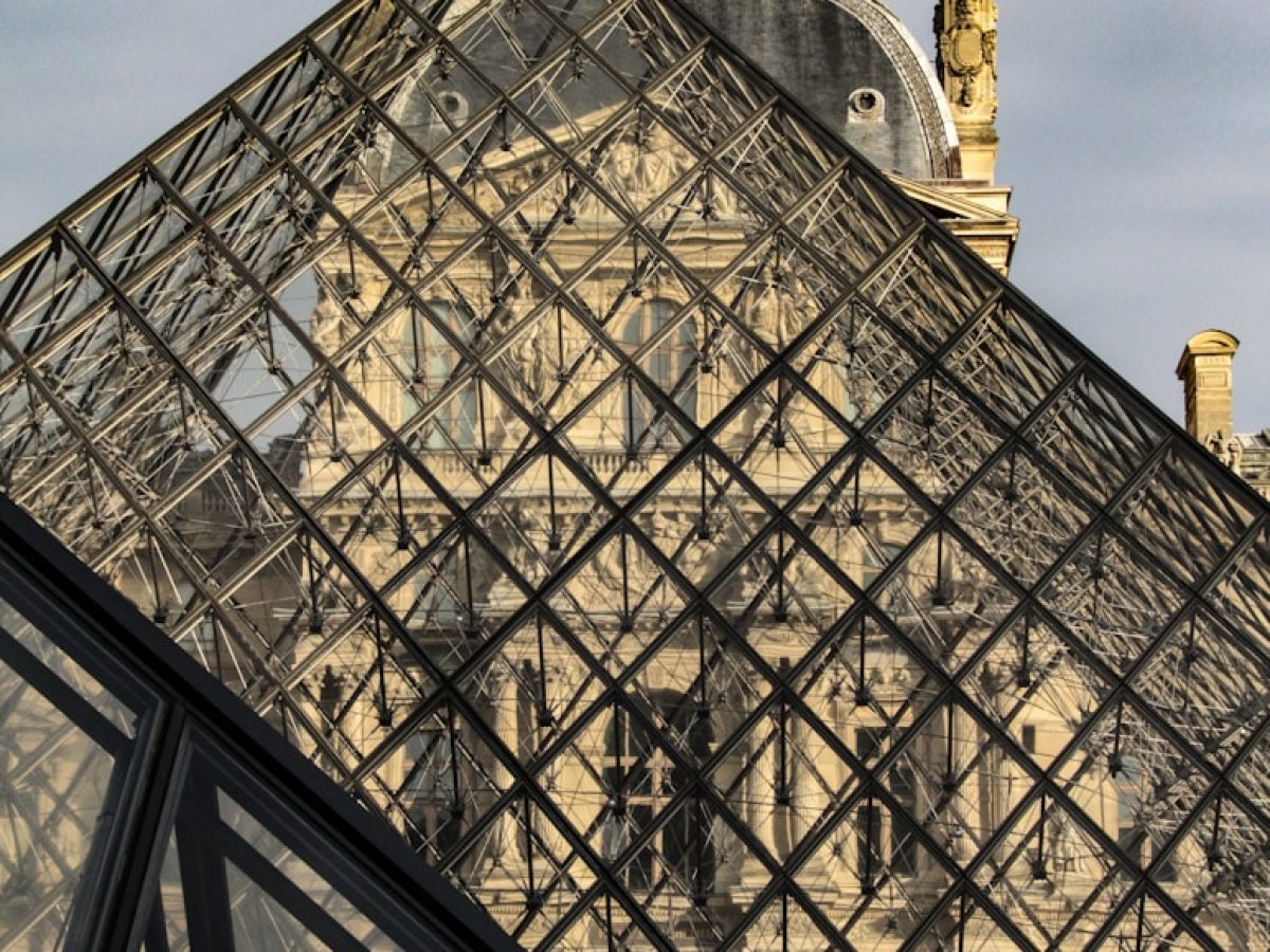 a large glass pyramid with a clock on top of it